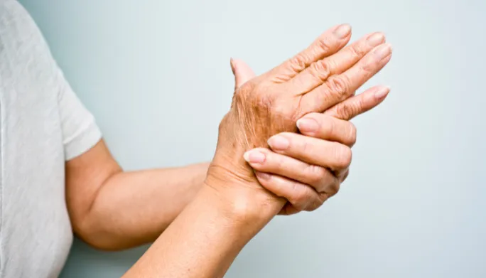 Close-up of a person massaging their own aching hand and wrist