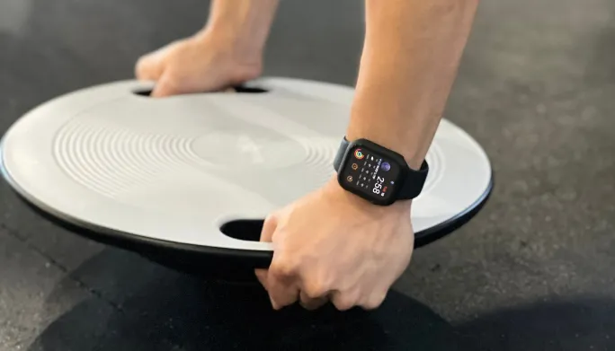 Close-up of hands and wrists bearing weight on a balance disc during exercise