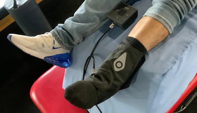 Patient's ankle wrapped in an electrical stimulation therapy device