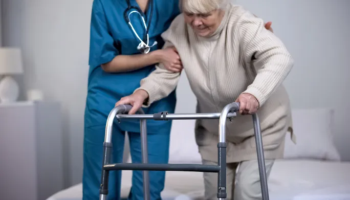 Clinician helping a patient walk using a walker