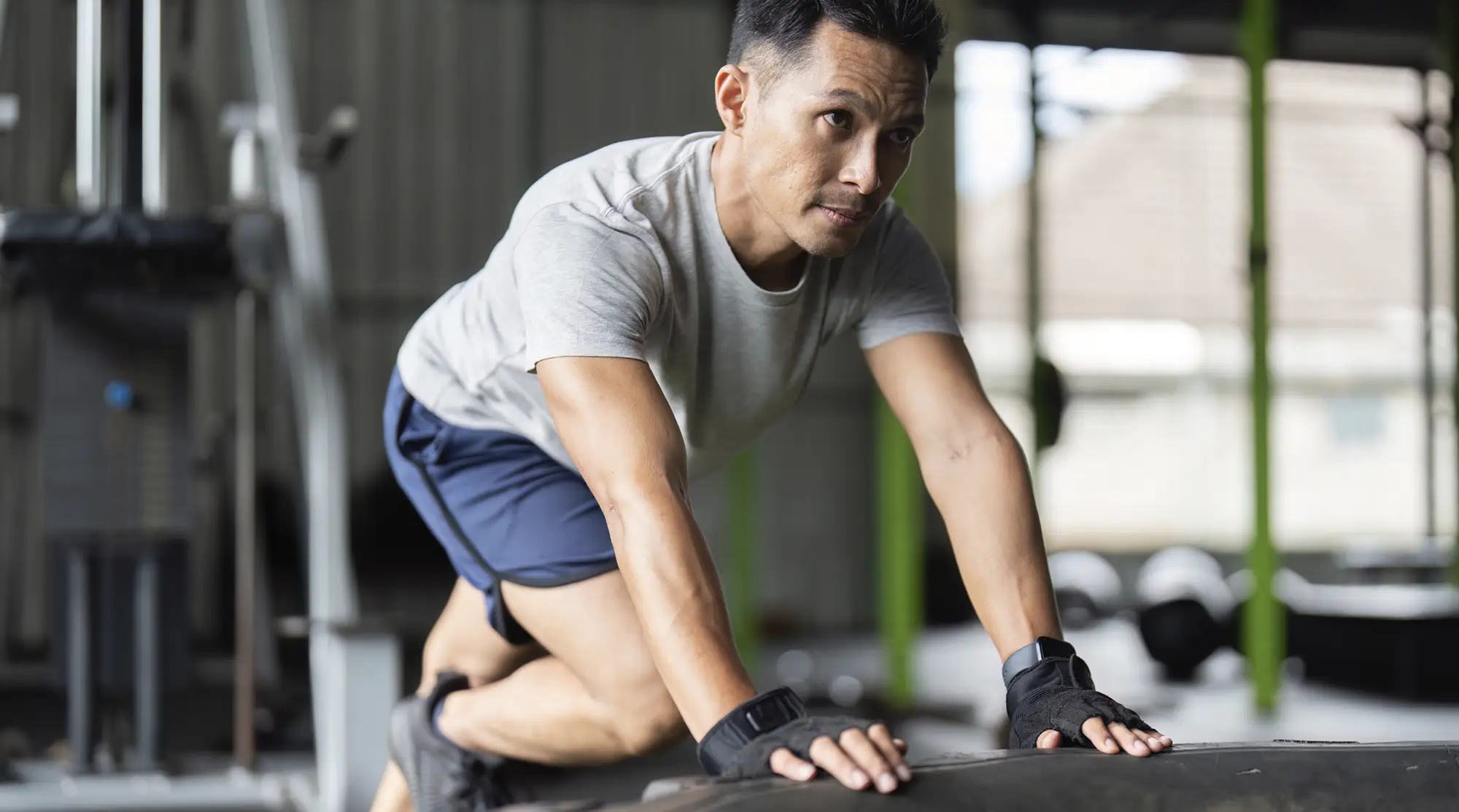 Athlete bracing on a training tire during a return-to-sport gym session